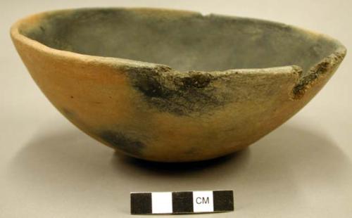 Ceramic bowl, fire-clouded red exterior, black interior, chipped rim