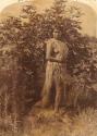 Kaiar; woman posed and standing near tree