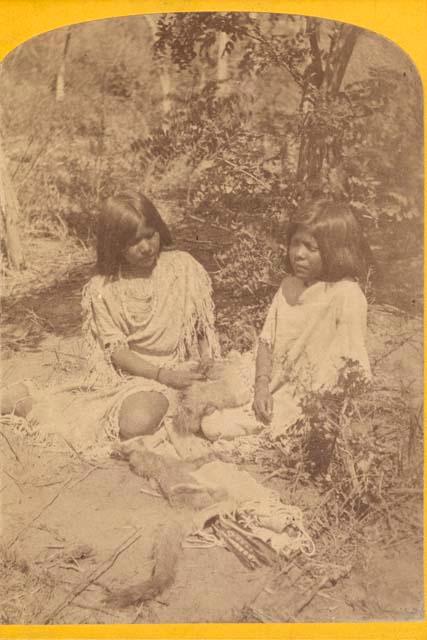 Two women, seated and working