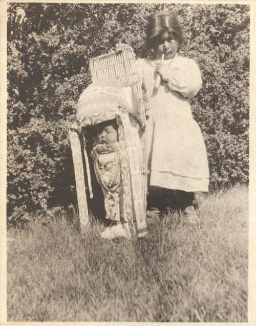 Ed. Somers' children-- a small girl standing alongside baby in a cradleboard