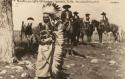 Ohquopo. Men on horseback in background.