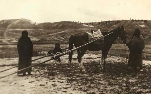 Two women with horse and child in travois