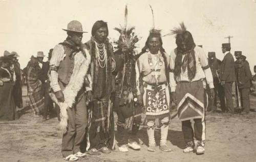 Group of five men, standing in line (dancing?)