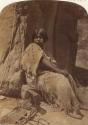 Woman seated before rocks