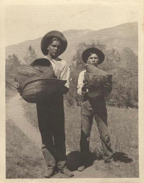 Two Mono boys carrying baskets