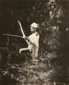 Boy kneeling, poised with arrow