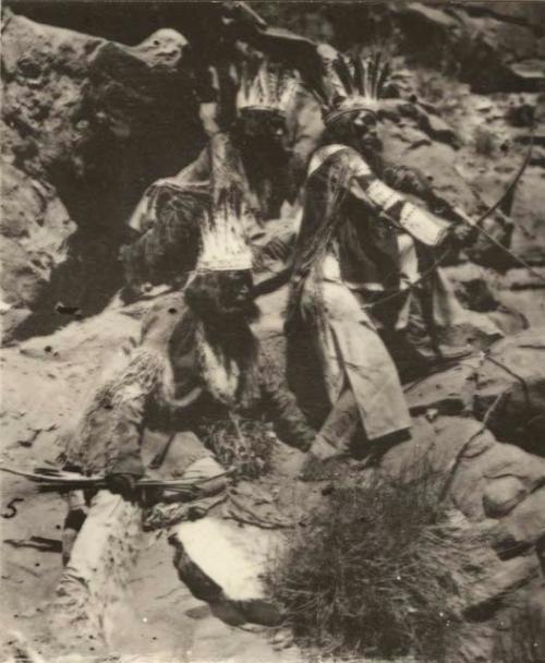 Three men alongside rocks with arrows