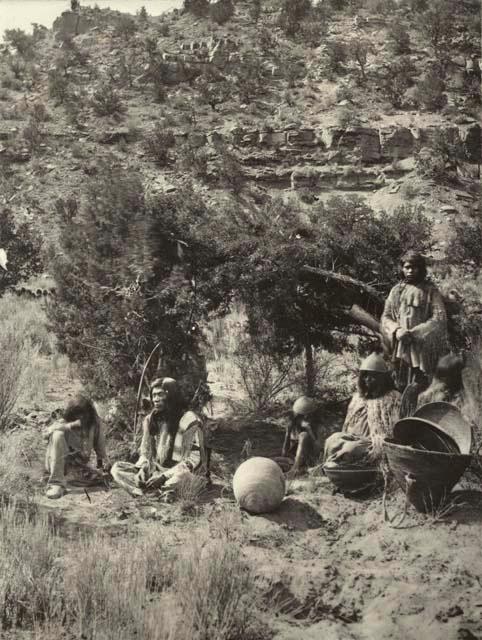 Several people seated around camp