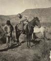 John Wesley Powell on horse speaking with another man