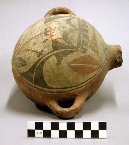 Red pottery canteen with black and white designs on upper part