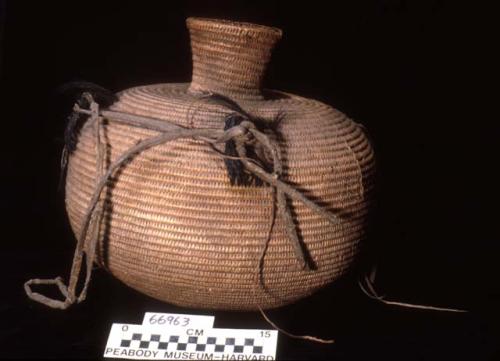 Large water jar, coiled. Made of bear grass. Horse hair handles with leather