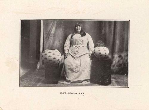 Studio portrait of Dat-so-la-lee sitting between two baskets