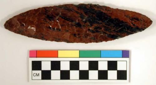 Chipped implement; chipped from red and black mottled obsidian