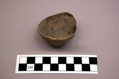 Ceramic, earthenware partial vessel, pinch pot, possible miniature, undecorated, shell-tempered; chipped stone, prismatic blade