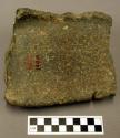 Metate fragment, thin rectangular fragment of side, possible red pigment stain i