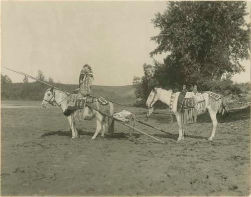 Mrs. Duck Chief posed on horseback and travois