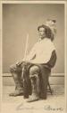 Studio portrait of seated man holding rifle