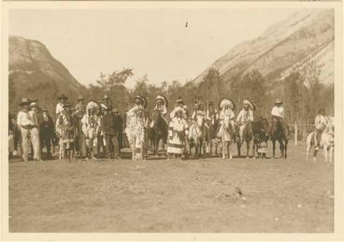 Line of men (dressed for war?) in headdress, some are mounted on horses