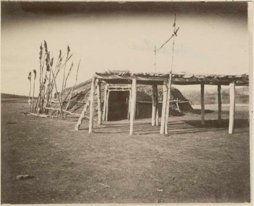 Earth lodge with entry drying frame, notched ladder and sacrificial pole