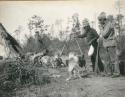 Two men feeding dogs, Basswood Lake.

