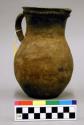 Coffee pot or pitcher with handle and notched fillet. Made of micaceous clay.
