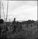 A group of men carrying a wounded young warrior to safety