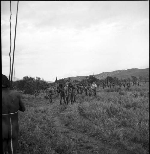 A group of men carry a wounded young warrior to safety