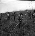 Warriors carrying their spears, walk towards the camera