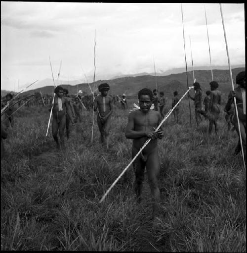 Warriors carrying their spears, walk towards the camera