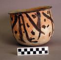 Ceramic, earthenware bowl, rounded base, straight walls, flared rim with finger marks, black painted design