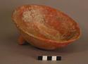 Ceramic, earthenware complete vessel, bowl with tripod base, one fragmented leg, red slip; mended