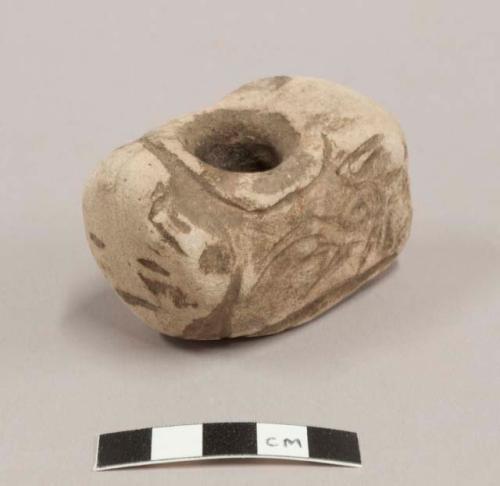 Stone effigy pipe made of sandstone with human face etched on one end. Br