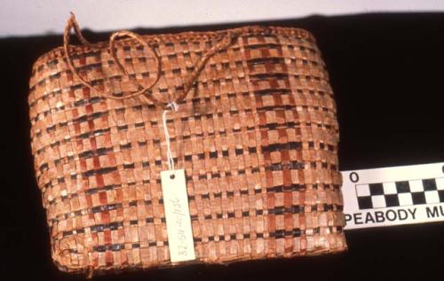 Bag-shaped basket with brown, red, and straw colors used in decoration