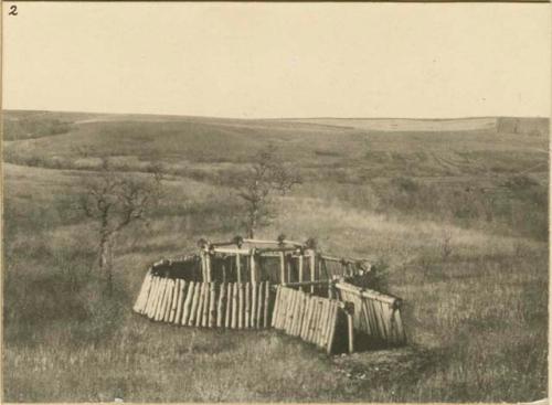 Model of an earth lodge, made by Miss Gay, with cotton wood slabs in place