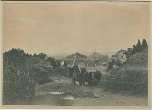 People Seated on top and Standing beside a Pawnee Earth Lodge