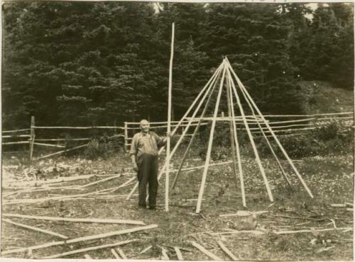 Constructing wigwam; Adding hoop to foundation of pole frame