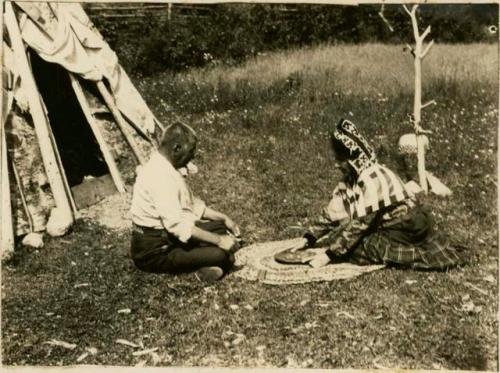 Mr. and Mrs. Christopher Morris playing the waltes'tagɣn, a Micmac bowl and dice game