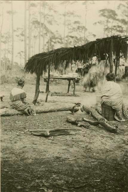 Seminole women sitting in camp