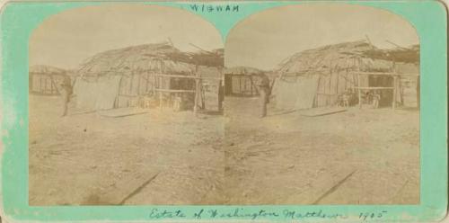 Photograph of children seated in front of a Wigwam.