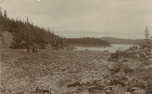 Three men on the shore of Oil Island, a camping ground of Indians