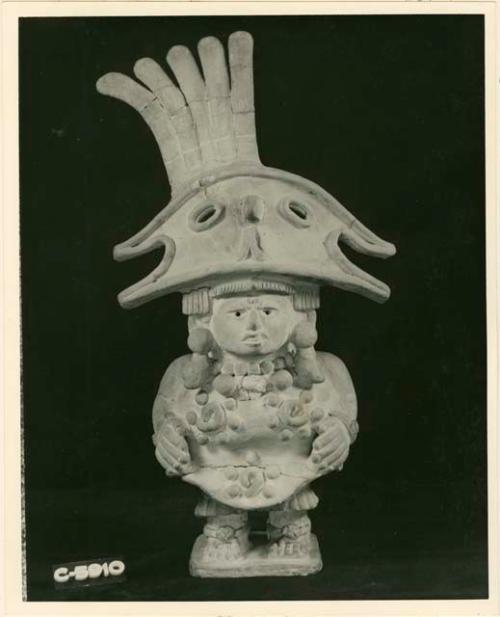 Standing figure of young male personage wearing the headdress dedicated to the God with the Helmet of the Bird with the Broad Beak