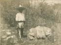 Man standing beside a part of an excavated stone monument