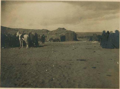 Groups of Navajo men, with building in background