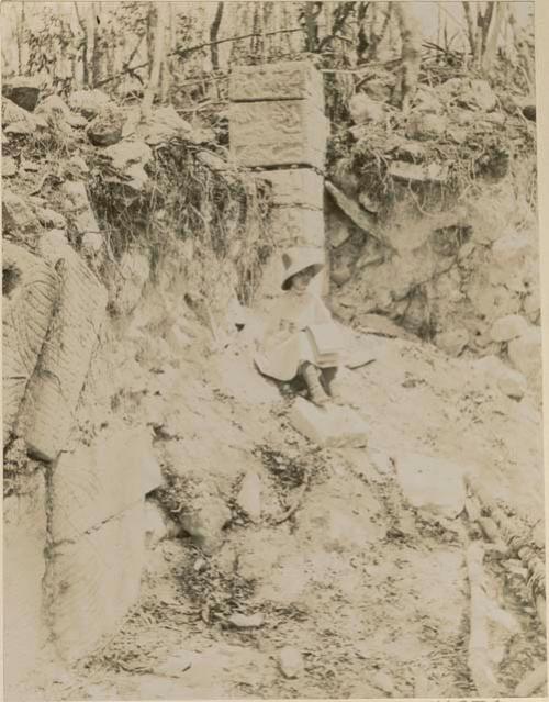 Woman seated amongst ruins, sketching