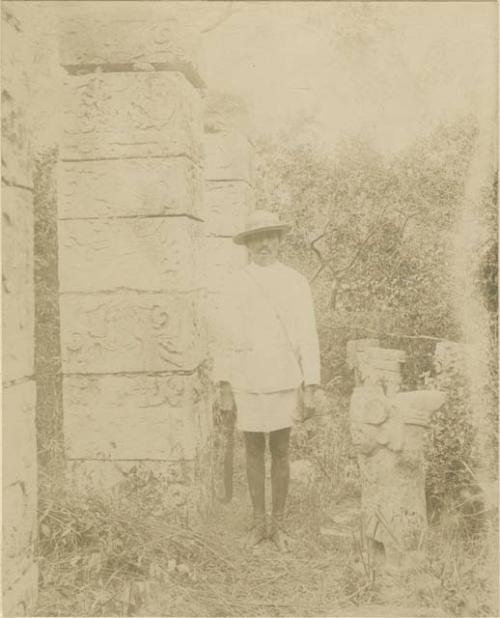 Man standing beside hieroglyphic columns at Chichen Itza