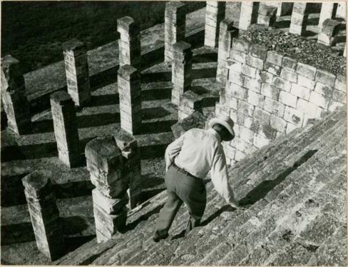 A.M. Tozzer climbing down the steps of a ruin