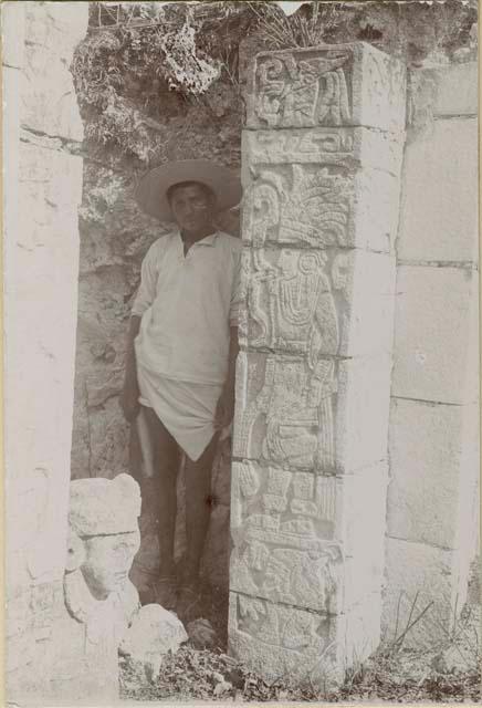 Man standing beside hieroglyphic column at Temple of the Tables