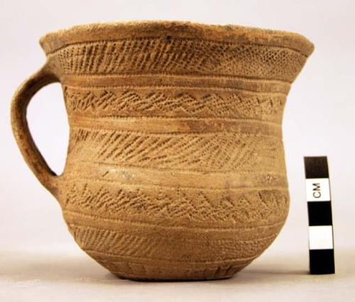 Pottery cup with band handle, impressed decoration