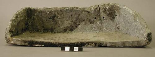 Ground stone vessel fragment, mended, two perforations in bottom