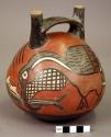 Early Nasca double spout bottle portraying a pelican eating a fish